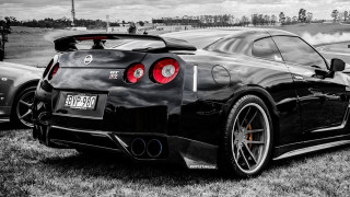 Black sports car parked field - other car behind free wallpaper