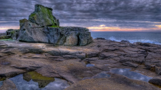 Rock beach sunset water mountains - a sunset in the background and a body of water free wallpaper