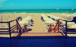 Beach umbrellas chairs sunset ocean - tilt shift free wallpaper