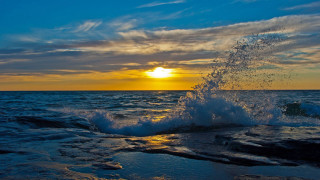 Wave sunset ocean beach sky - the sun in the distance behind free wallpaper