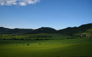 Green field mountains clouds sky - a green field free wallpaper