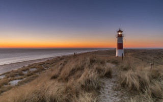 Lighthouse grassy hill ocean sunset 2 - radiant free wallpaper