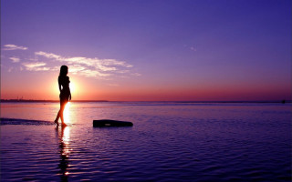 Woman beach sunset rock reflection - the sun setting behind her free wallpaper
