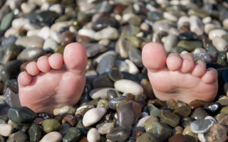 Barefoot rocks pebbles beach foreshortening - free beach wallpaper