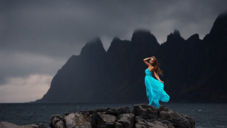 Woman blue dress rocks ocean - a dark sky free wallpaper
