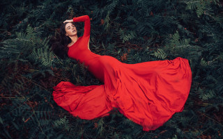 Woman red dress laying field - her arm behind her head free wallpaper