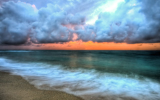 Beach waves cloudy sky surfboard - a surfboard in the foreground free wallpaper