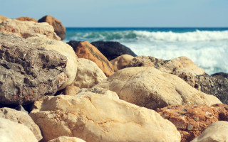 Rocks water beach wave mountains - deep depth of field free wallpaper