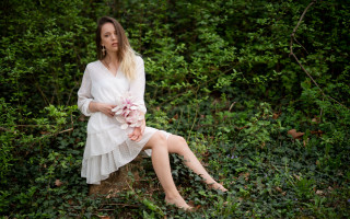 Woman sitting rock field bushes - daphne mcclure free wallpaper