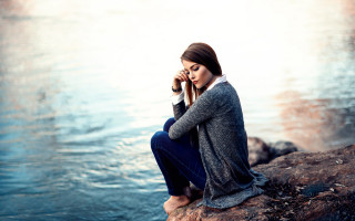 Woman sitting rock water phone - portrait photography free wallpaper