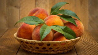 Basket peaches leaves wooden table 2 - a wooden table top free wallpaper