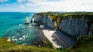 Sailboat cliff beach lake mountain - a sailboat free wallpaper