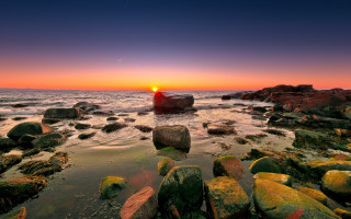 Sunset rocky beach boat mountain 3 - a sunset over a rocky beach free wallpaper