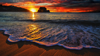Sunset ocean waves rocks cityscape - a sunset over the ocean free wallpaper