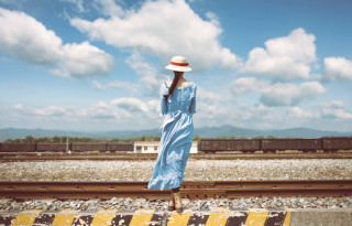 Woman blue dress hat train - a train track in the background free wallpaper
