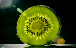 Kiwi slice flat black background - a table top free wallpaper