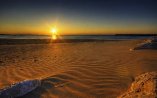 Sunset beach rock ocean cloud - a sunset over a beach free wallpaper