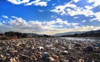 Rocky river bed clouds trees - river free wallpaper