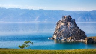 Mountain lake rock tree beach - the background and a tree in the foreground free wallpaper