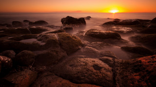Sunset rocky beach orange sun - a sunset over a rocky beach free wallpaper