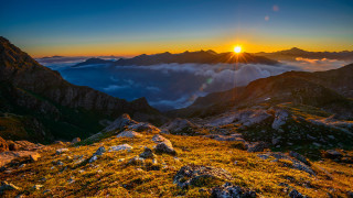 Sunset mountain range clouds horizon - a sunset over a mountain range free wallpaper
