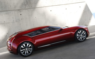 Red car driving next to - a white wall free wallpaper
