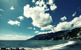 Beach mountain water sky boat - a mountain in the background and a body of water free wallpaper