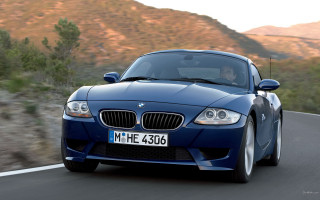Blue car driving mountain road - a person in the driver seat free wallpaper