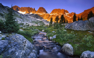Lush forest stream mountains sunset - a mountain range in the background free wallpaper