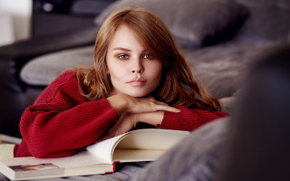 Woman couch book serious portrait - a book in her hand free wallpaper