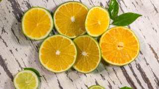 Oranges halved leaves wooden table - a group of oranges free wallpaper