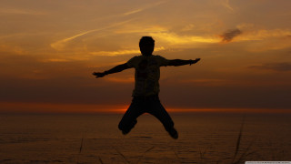 Man jumping sunset arms outstretched - his hands out free wallpaper