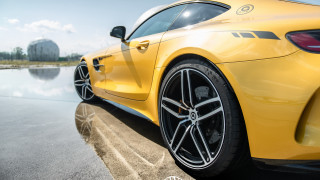 Yellow sports car water building 2 - the side of a road near a body of water free wallpaper