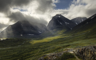 Mountain range clouds grassy field 2 - a grassy field below free wallpaper