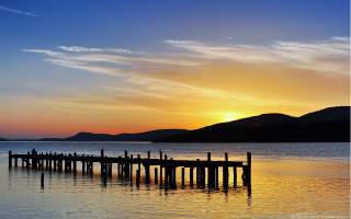 Sunset dock mountains water clouds 2 - a sunset over a body of water free wallpaper