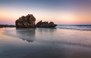 Rock formation beach sunset reflection - the background and the water free wallpaper