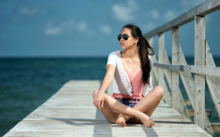 Woman pier sitting blurry beach - a pier free wallpaper