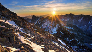 Mountain sunset snow rocks ocean - a few rock below free wallpaper