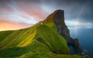 Rainbow over grassy mountains landscape - the water below free wallpaper
