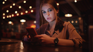 Woman serious cellphone table lights - above her free wallpaper