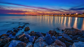 Sunset rocky beach cityscape water - a matte painting free wallpaper for desktop