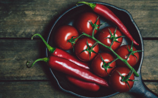 Red peppers pan wooden table - a spoon free wallpaper