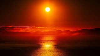 Sunset mountains water orange sky - a sunset over a body of water free wallpaper