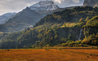 Mountain waterfall grassy field trees - a grassy field below free wallpaper