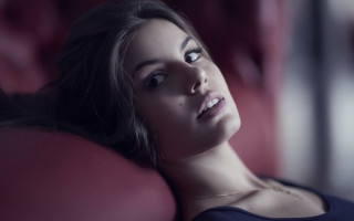 Woman laying red couch portrait - a red couch free wallpaper