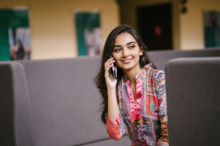 Woman sitting couch talking phone - a cell phone free wallpaper