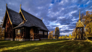 Wooden church thatched roof steeple - a grassy field free wallpaper