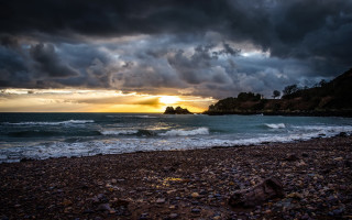 Beach rocks water cloudy sunset - stormy weather free wallpaper