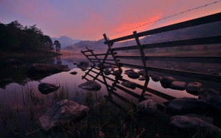 Wooden fence water sunset mountains - rich moody colour free wallpaper