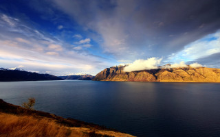 Mountain lake cloudy sky grassy - mountain under a cloudy sky free wallpaper